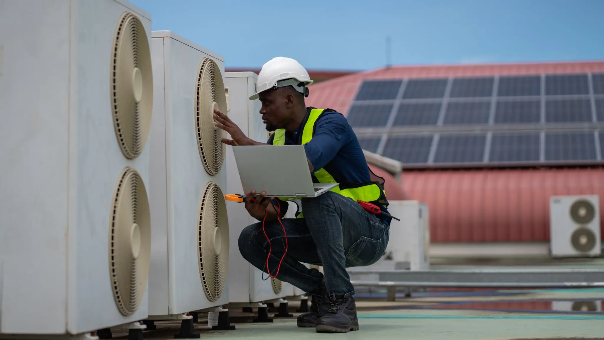 Technician inspecting rooftop air conditioning units.