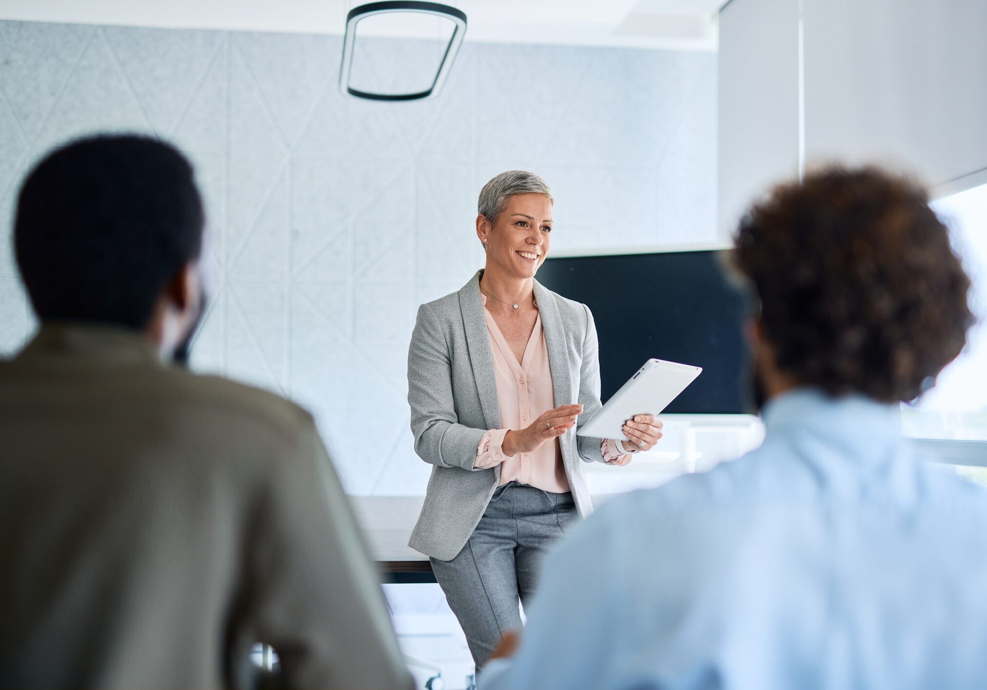 Woman presenting to colleagues in a meeting.