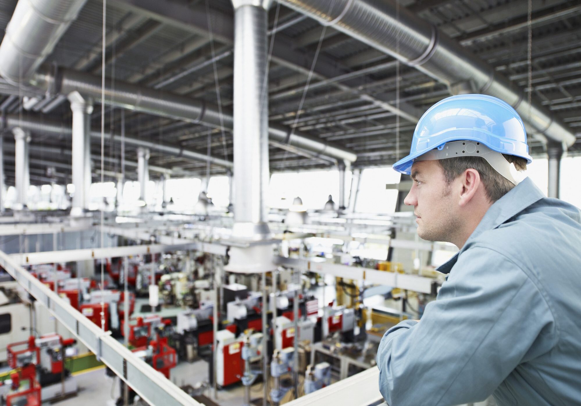 Man observing large industrial factory floor.