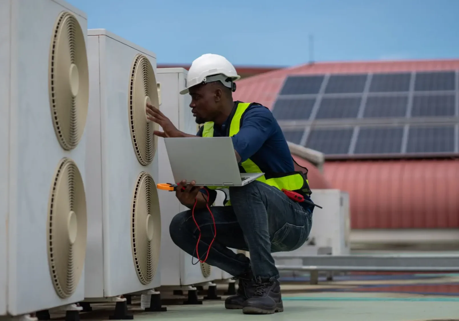 Technician inspecting rooftop air conditioning units.