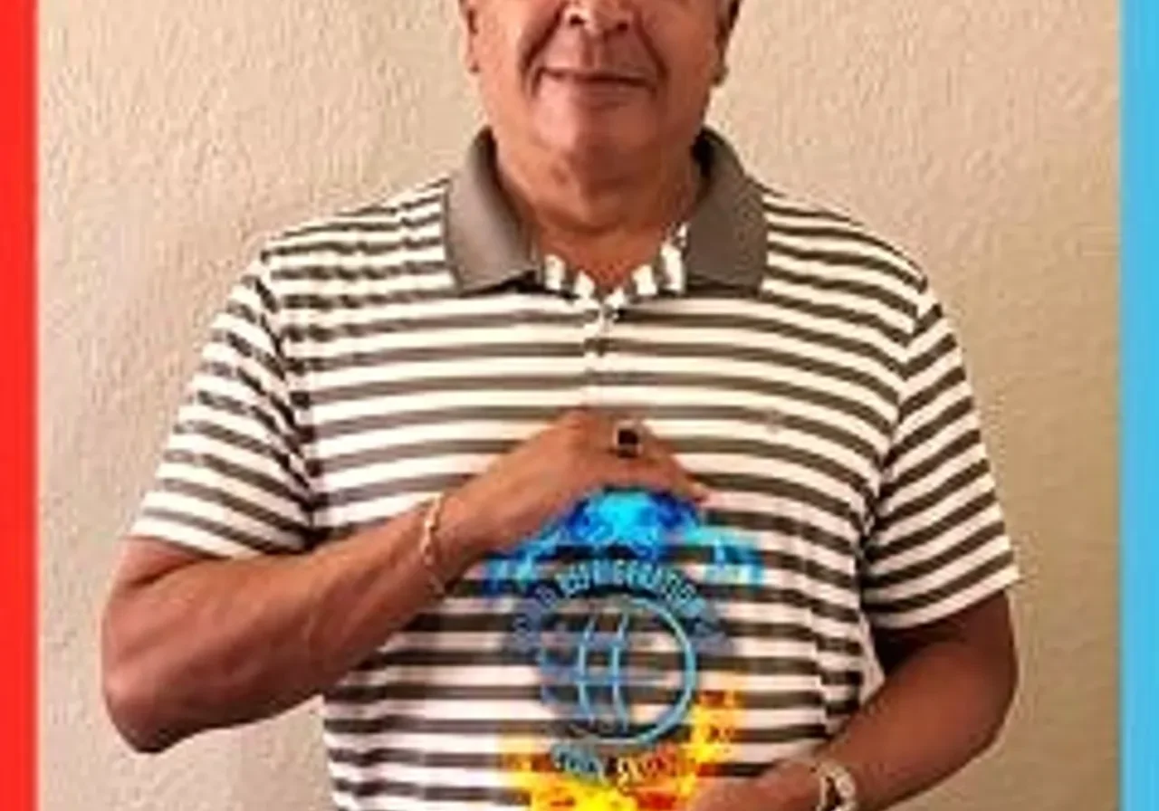 Man holding colorful award, wearing striped shirt.